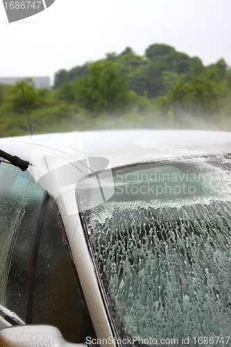 Image of a car wash with a jet of water and shampoo