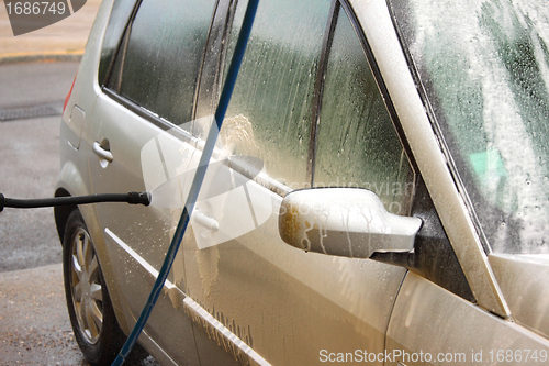 Image of a car wash with a jet of water and shampoo