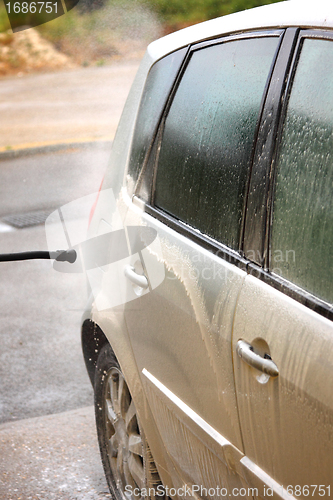 Image of a car wash with a jet of water and shampoo