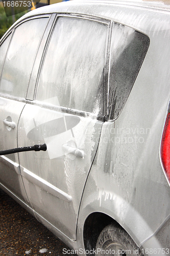 Image of a car wash with a jet of water and shampoo