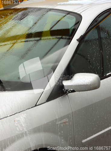 Image of a car wash with a jet of water and shampoo