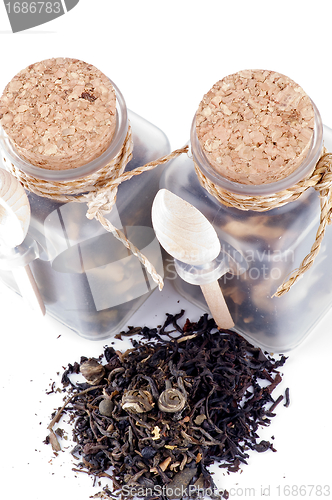 Image of Tea leaves in transparent parisons with wooden spoon