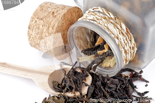 Image of Tea leaves in transparent parison with wooden spoon