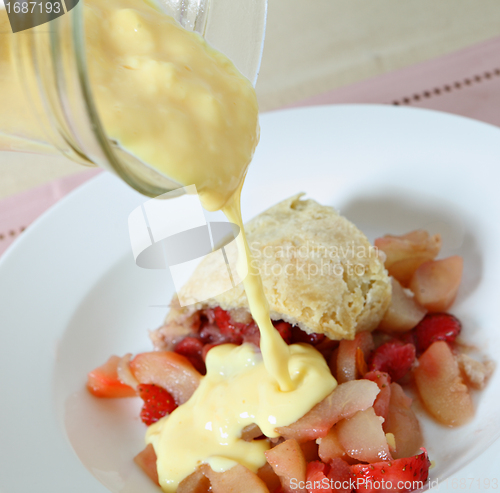 Image of Pouring custard on fruit pudding