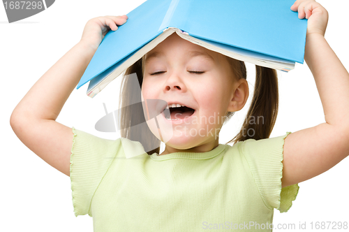 Image of Cute little girl plays with book