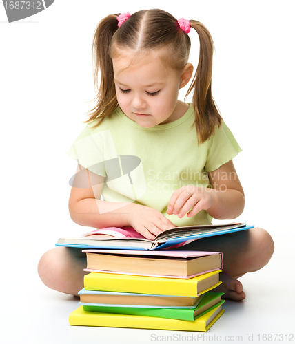 Image of Cute little girl reads a book
