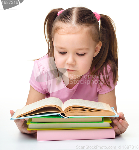 Image of Cute little girl reads a book