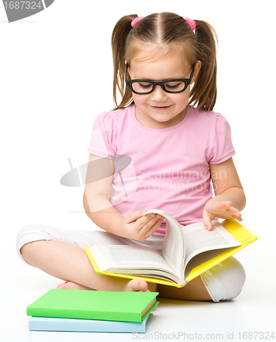 Image of Cute little girl reads a book