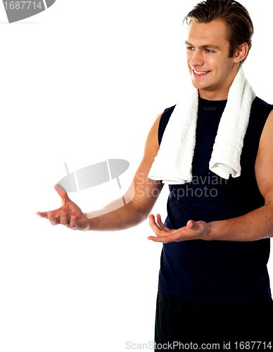 Image of Male trainer posing with open hands and looking away