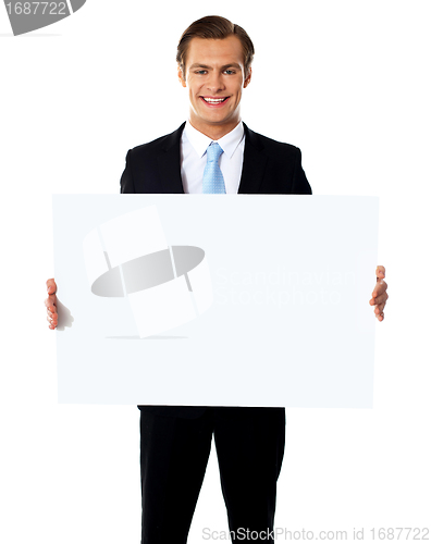 Image of Young businessman holding white blank billboard