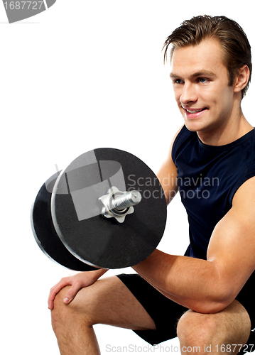 Image of Strong young man working out with dumbbells