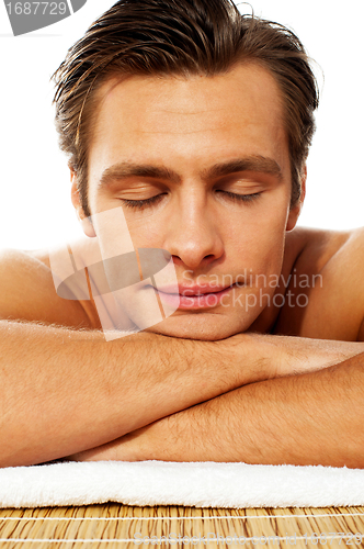 Image of Attractive man resting with closed eyes at spa