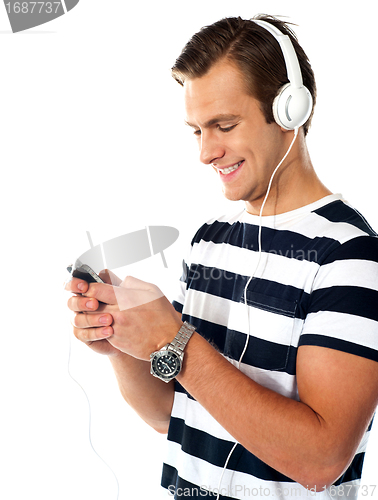 Image of Male teenager with mp3 player and earbuds