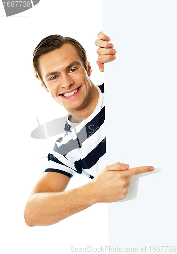 Image of Handsome person pointing towards blank signboard