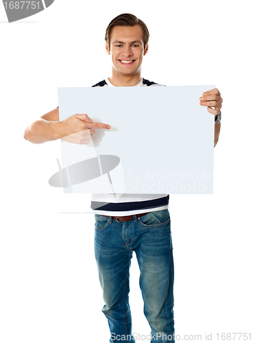Image of Portrait of young man pointing at blank signboard