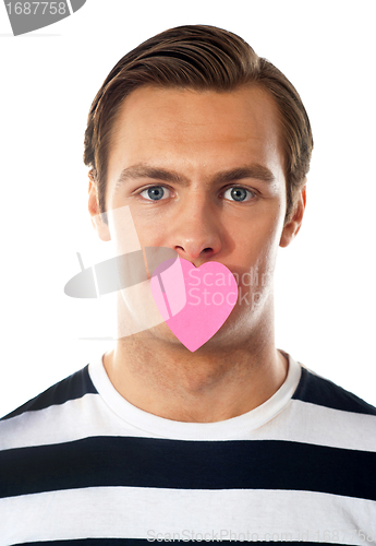 Image of Good looking guy with heart shaped paper on his mouth