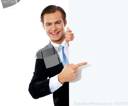 Image of Business person pointing towards blank signboard