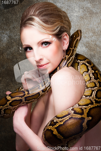Image of Attractive nude blond woman with python on grey