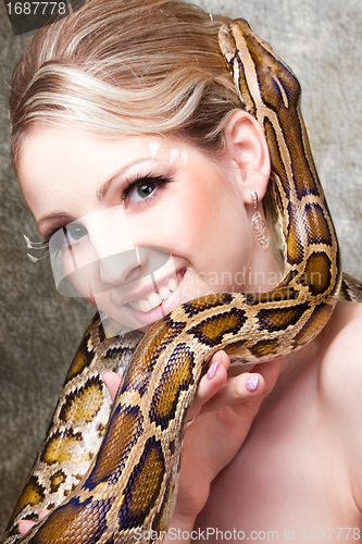 Image of Attractive nude blond woman with python on grey