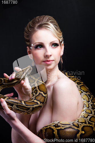 Image of attractive nude blond woman with python on black