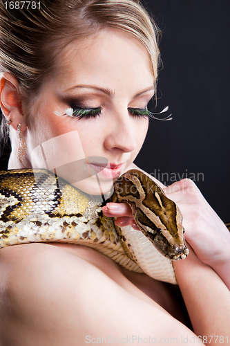 Image of attractive nude blond woman with python on black
