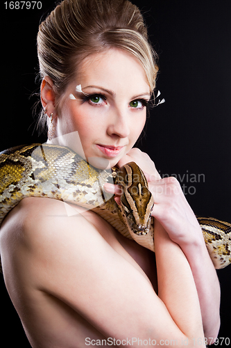 Image of attractive nude blond woman with python on black