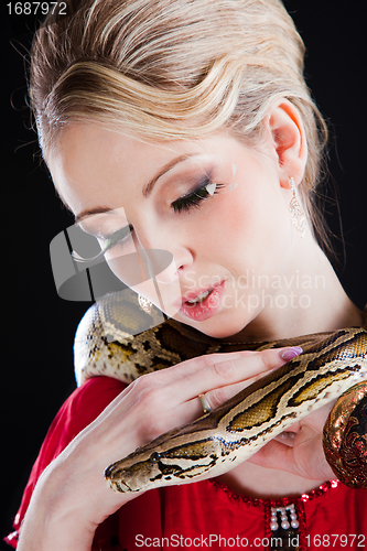 Image of attractive blond woman with python on black