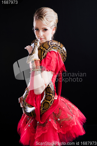 Image of beautiful ballerina girl in a red scenic dress with  python on black