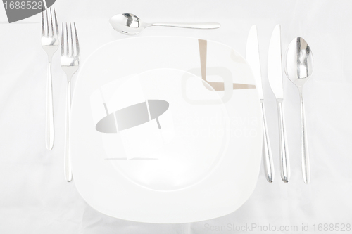 Image of Plates with a silver fork, spoon, dessert spoon and a knife 