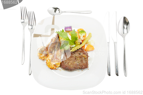 Image of Grilled steak and shrimp served on mashed potatoes with vegetabl