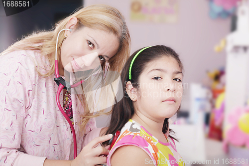 Image of Pediatrician examining little girl with stethoscope 