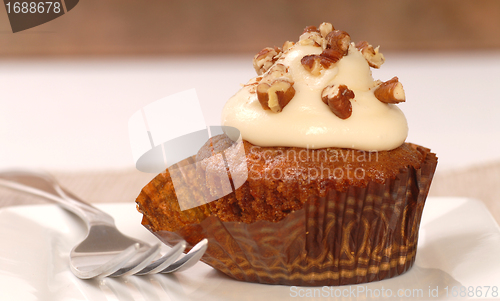 Image of Delicious carrot cake cupcake with cream cheese frosting and nut