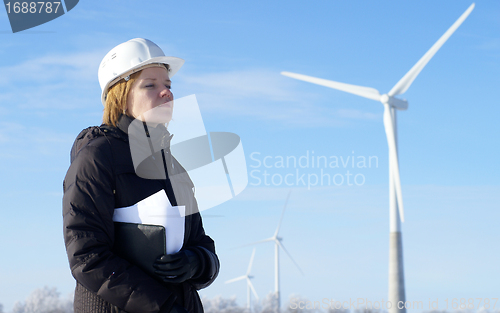 Image of engineer or architect with white safety hat and wind turbines on