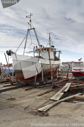 Image of small vessel in dry dock with cloudy sky in background