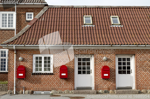 Image of red mailboxes on stone walled house