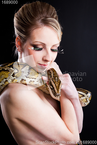 Image of attractive nude blond woman with python on black