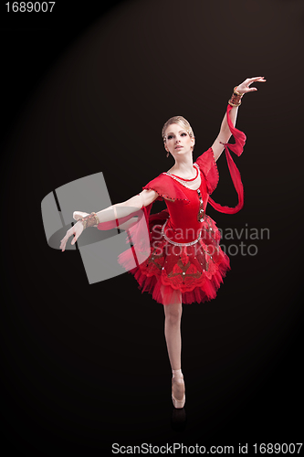 Image of beautiful ballerina wearing red tutu posing on black 