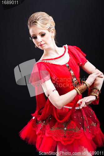 Image of ballerina wearing red tutu posing on black