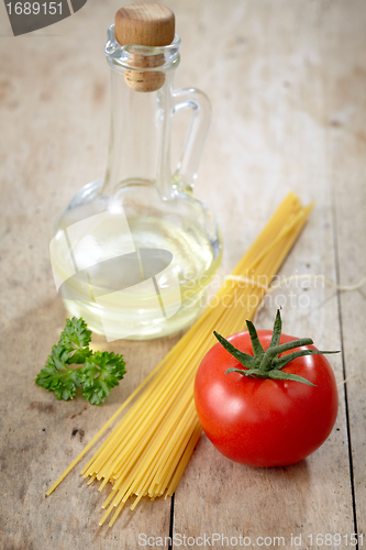 Image of tomato and spaghetti on old wooden table