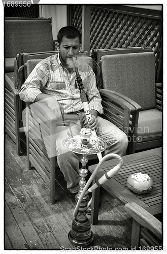 Image of Man smoking waterpipe