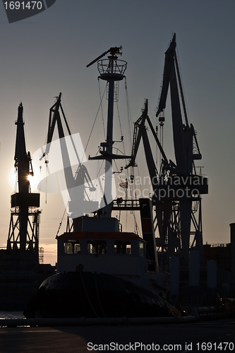 Image of shipyard cranes and tugboat