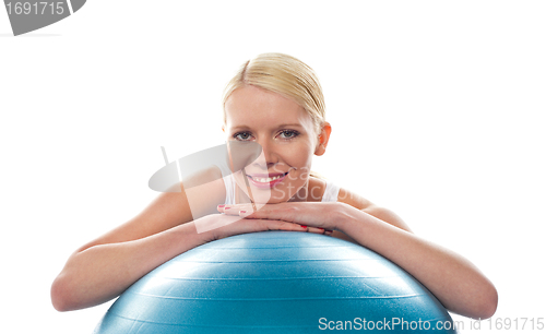Image of Attractive fit young woman resting chin over ball
