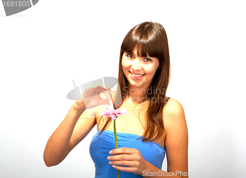 Image of young beautiful brunette woman with a flower happy