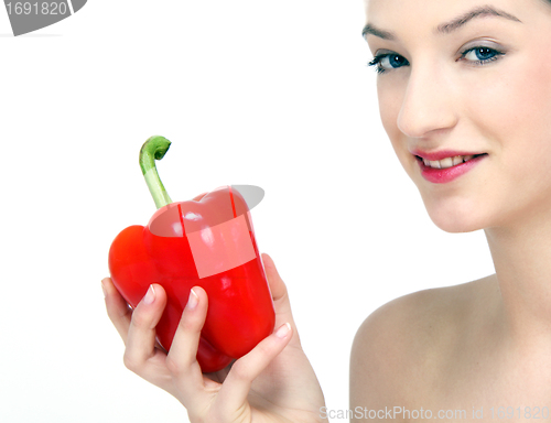 Image of young beautiful girl with a red pepper in her hand