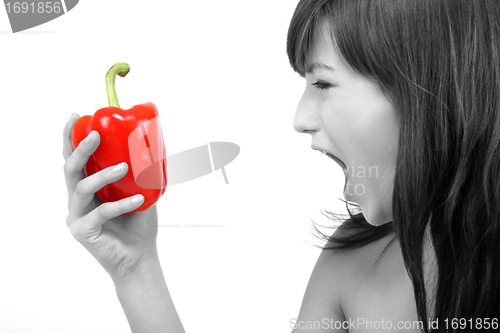 Image of young beautiful girl with a red pepper in her hand