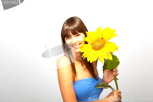 Image of young beautiful brunette woman with a flower happy