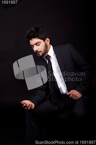 Image of young successful business man with a suit isolated on black background