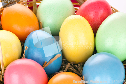 Image of eastern eggs in different colours in a basket with a rabbit