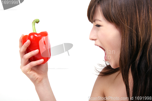 Image of young beautiful girl with a red pepper in her hand