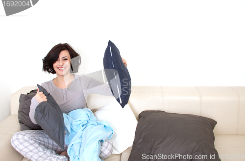 Image of young beautiful woman is sitting an a sofa and relaxing